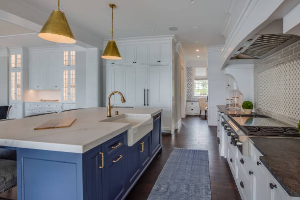 Kitchen galley with dark hardwood floors and blue rug to match island cabinets